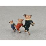 A novelty miniature cold painted Vienna bronze group of three dressed little pigs in a line,