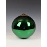 A large 19th century green glass witches ball, having a mirrored effect, ornate circular metal