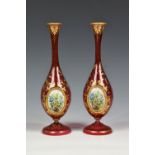 A pair of late 19th century Bohemian cranberry glass bottle vases, decorated with delicate hand