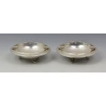 A pair of Greek Sterling silver ashtrays, of circular form with deep bowls and raised on three
