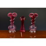 A pair of Victorian cranberry glass vases, with clear glass moulded shell feet, trailed spiral clear
