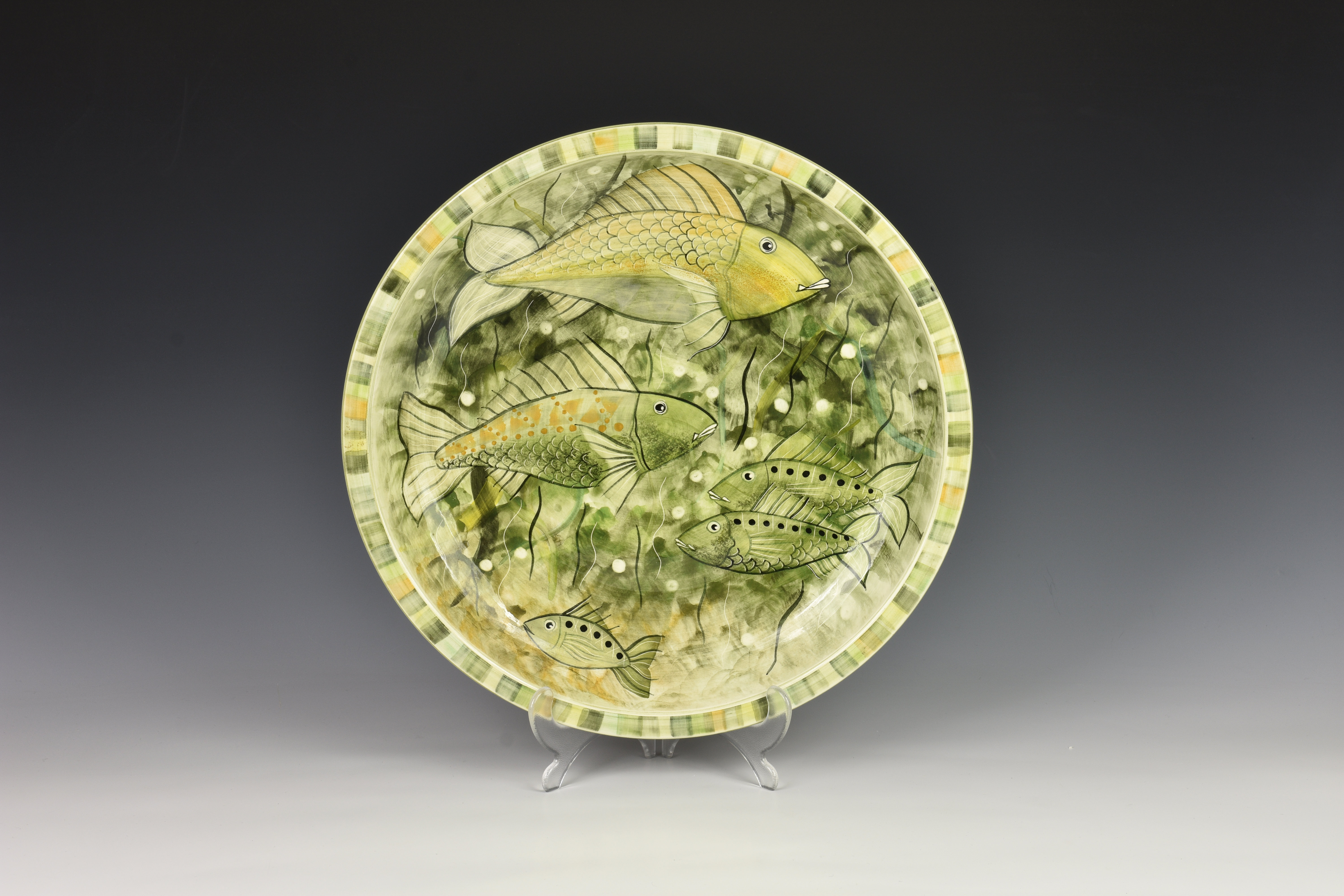 A large Jersey Pottery fish dish, of circular form, the flat rim dish, decorated with fish amidst