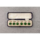 A cased set of vintage, rolled rose gold studs, in their original case and with green centre