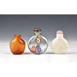 Three Chinese glass snuff bottles, probably early 20th century, one of rounded, flattened form, in