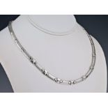 An 18ct white gold and diamond necklace and matching earrings, the necklace with alternate