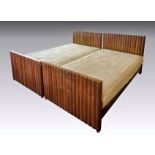 A pair of 1930s Art Deco oak single beds, the angular head and foot boards with bold reeded