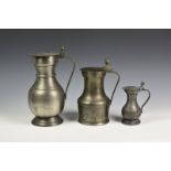 A matched graduating set of three French pewter flagons, of typical form with twin acorn thumbpiece,