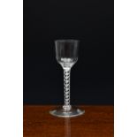 A mid-18th century airtwist wine glass, c.1760, the ogee bowl with basal fluting, on a double series