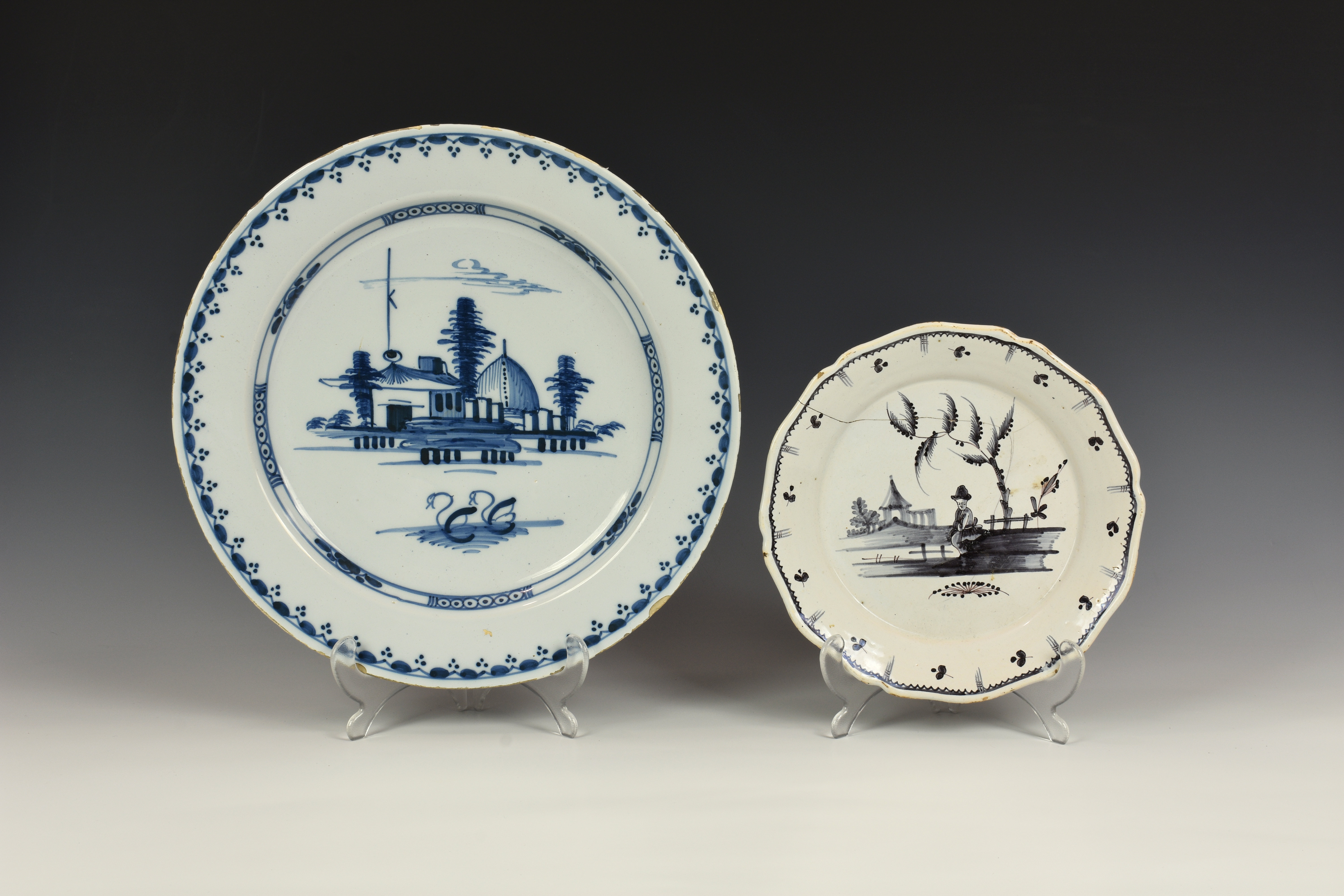 A Delft blue and white charger, the centre decorated with houses and a pair of swans, 13¼in. (33.