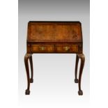 A George I style figured walnut bureau on stand, late 19th / early 20th century, the feather and