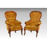 A matched pair of Victorian button back walnut showframe armchairs, the balloon shaped backs,