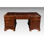 A good mid-19th century mahogany inverted breakfront partner's desk, the top with inset red gilt