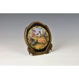 A antique brass cased easel clock by Gubelin of Lucerne, the face painted with a rustic scene of two