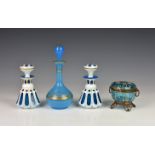A pair of 19th century cased glass scent bottles, lobed and faceted blue with white overlay,