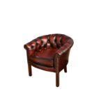 A red leather button back tub chair.