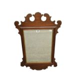 An early 19th century George II style mahogany fretwork mirror with rectangular plate and gilt slip,