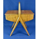 A vintage mid century sewing box, angular legs with domed handle to the top and two hinged lids to