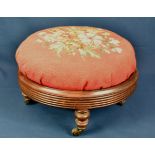 A 19th century circular mahogany footstool with reeded frame and four short baluster legs with