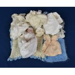 An antique miniature porcelain doll with clothing