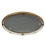 An oval antique-style mirror with cream & gilt frame and bevelled plate