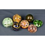 A small collection of various glass paperweights comprising a Baccarat green glass heart shaped