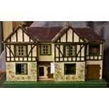 A Tri-ang double fronted doll's house c.1947, with moulded card roof, garage to the side and