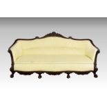 A late Victorian carved mahogany showframe settee the serpentine back with foliate, cabochon and