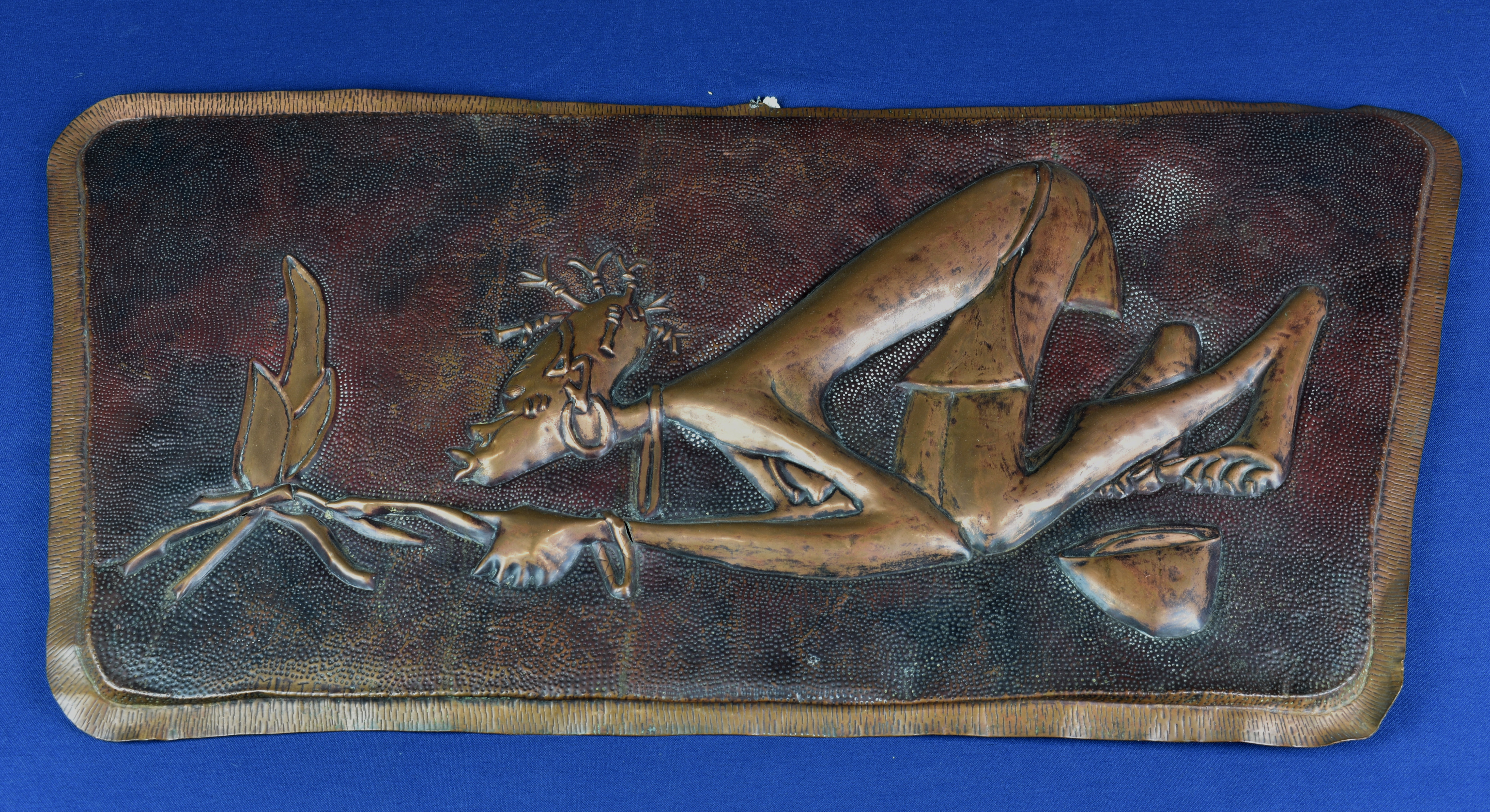 A vintage hand beaten African plaque of tapering rectangular form depicting a tribal man starting