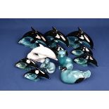 A collection of Poole Pottery figurines to include four large and five smaller dolphins; cat; duck