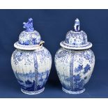 A matched pair of Delft vases and covers 19th century or earlier, of ribbed ovoid form, painted with