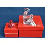 Two boxed Baccarat glass paperweights one of a seated female figure reading a book, 5in. (12.6cm.)