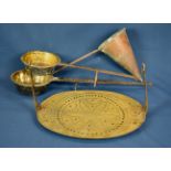 A 19th century or earlier pierced brass hanging trivet stand of oval form with two tapered side arms