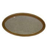 An oval gilt wall mirror with bevelled glass (45cm x 81.5cm)