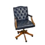 A leather swivel desk chair with buttoned back and seat