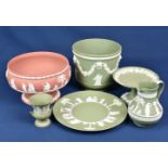 A small collection of Wedgwood jasper ware in green and terracotta with raised white classical