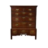 A George III oak chest on stand, the moulded top over two short and three long graduated drawers,