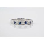 An 18ct white gold, sapphire and diamond wedding band, featuring 5 round cut sapphires and 4 round