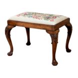 A George I style walnut stool, circa 1900, the drop in seat with ivory ground floral petit point