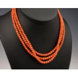 An antique 3 stranded coral bead necklace, together with a single strand pearl necklace, the