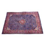 A Kashan rug, second half 20th century, the central red medallion on a blue ground with all over