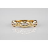 An 18ct yellow gold and diamond set ring, each trio of diamonds divided by reeded bars and the