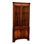 A Georgian style inverted bowfront corner cupboard, the dentil carved cornice over a pair of