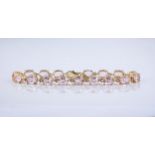 A 9ct yellow gold and morganite line bracelet, featuring pale pink, oval cut morganites measuring