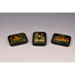 Three modern Russian painted and lacquered trinket boxes, each of rectangular form, one decorated