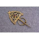 An Indian gold scarf pin with central ruby, the ruby of mixed, oval cut and pinkish red colour and