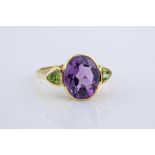 An 18ct yellow gold, amethyst and peridot cocktail ring, featuring a central, oval cut amethyst of