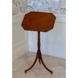 A George III mahogany and ebony lined adjustable reading table, the octagonal fielded top with brass