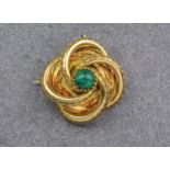 An antique gold and malachite brooch, featuring a round cabochon malachite stone to the centre of