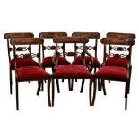 A set of seven George IV mahogany sabre leg dining chairs, including one carver, the label top rails