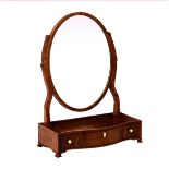 A George III mahogany serpentine box base toilet mirror, the oval mirror on shaped uprights, over